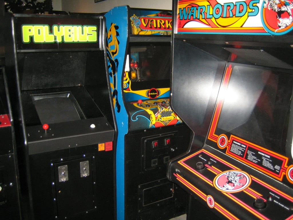 Polybius — perfeita para relaxar… se “relaxar” inclui ansiedade crescente, luzes piscando na sua alma e a leve impressão de que o jogo está analisando você melhor do que você mesmo. Insira a ficha, perca a sanidade e ganhe… bom, ninguém nunca ficou tempo suficiente para contar.